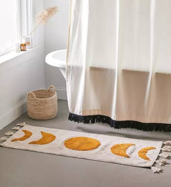 the moon phase bath mat in front of a tub