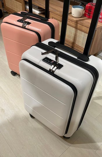 reviewer photo of salmon pink and white hard-side suitcases