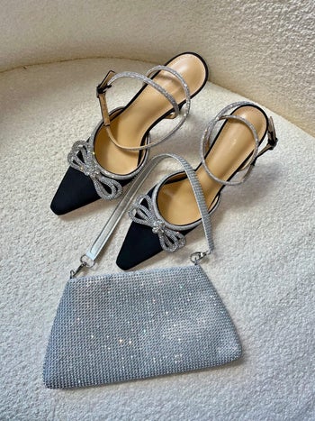a silver sparkly purse on top of a pair of black pumps