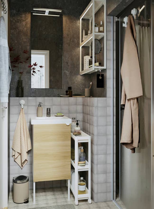 Modern bath  with a compact sink, retention  shelves, partition  mirrors, and assorted  toiletries neatly arranged for an businesslike  layout