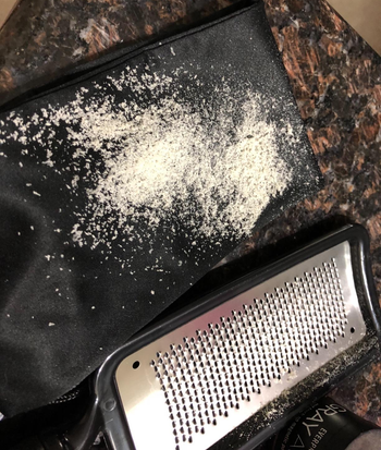 reviewer photo of the foot rasp next to a pile of dry skin flakes the rasp removed from their feet