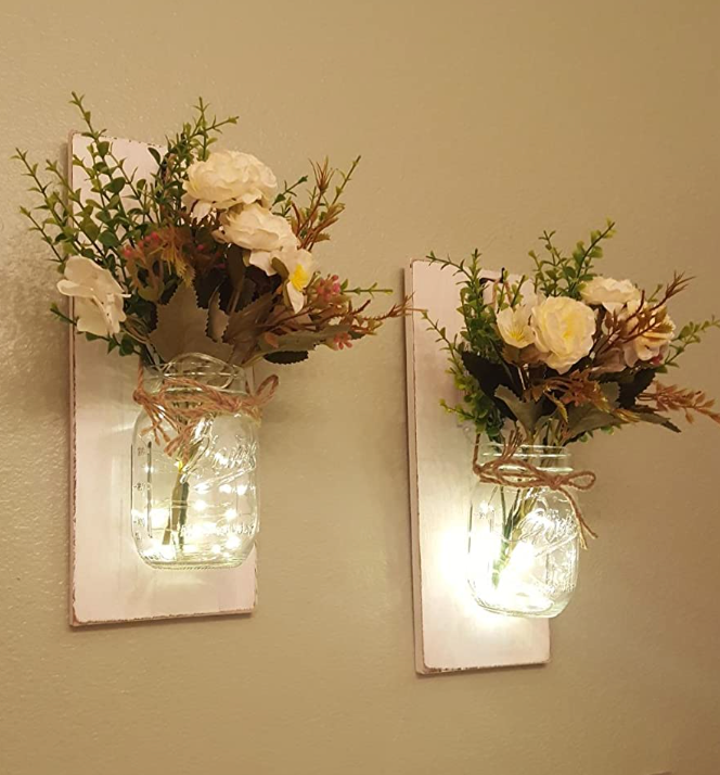 Reviewer photo of the two sconces lit and hanging on a wall