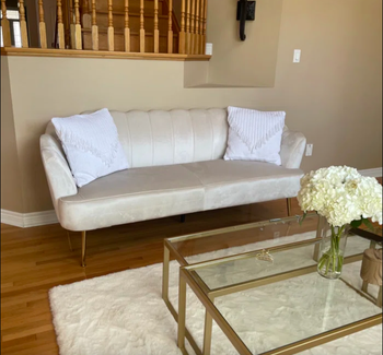 reviewer photo of scalloped white velvet couch in living room