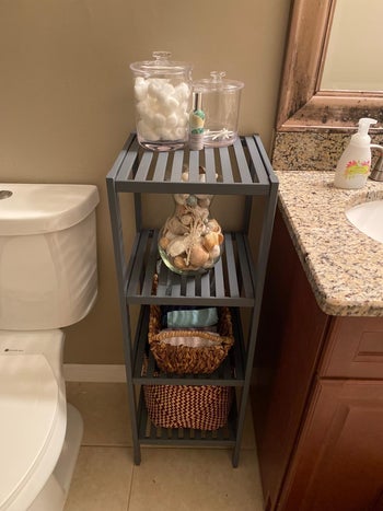 Reviewer image of product in gray standing between toilet and counter with baskets on lower shelves