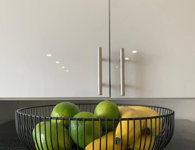 reviewer image of black wire fruit basket with limes and bananas in it