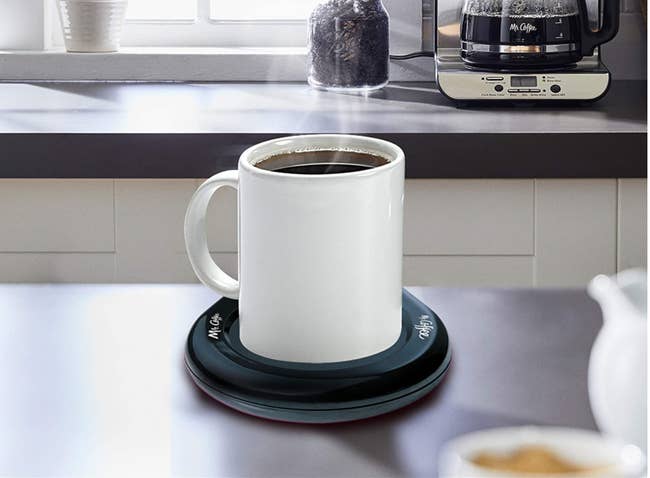 mug of coffee on the black warmer pad 