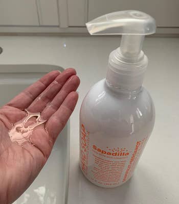 Reviewer image of white and orange bottle of soap