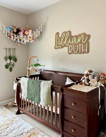 Cozy nursery with a woody  crib, stuffed animals, and a sanction  motion   above. Decor includes a mobile and macramé partition  hangings