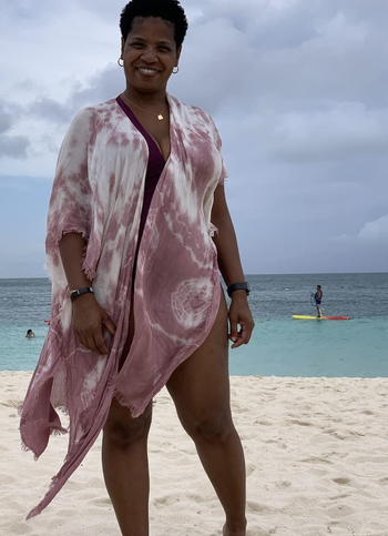 a reviewer wearing the cardigan featuring a pink tie-dye print over a swimsuit 