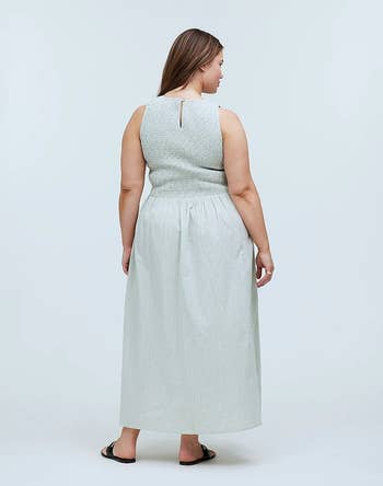 Woman in a sleeveless, textured midi dress with a keyhole back