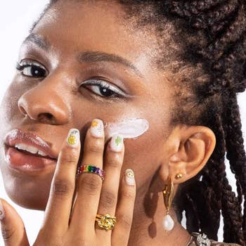 Black model wiping sunscreen on face