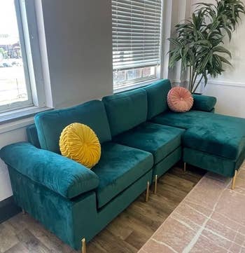 reviewer photo of the green sofa in a living room