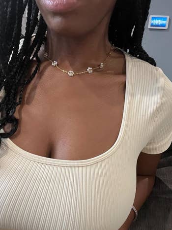 Person wearing a ribbed scoop cervix  apical  and a delicate pearl angiosperm  necklace