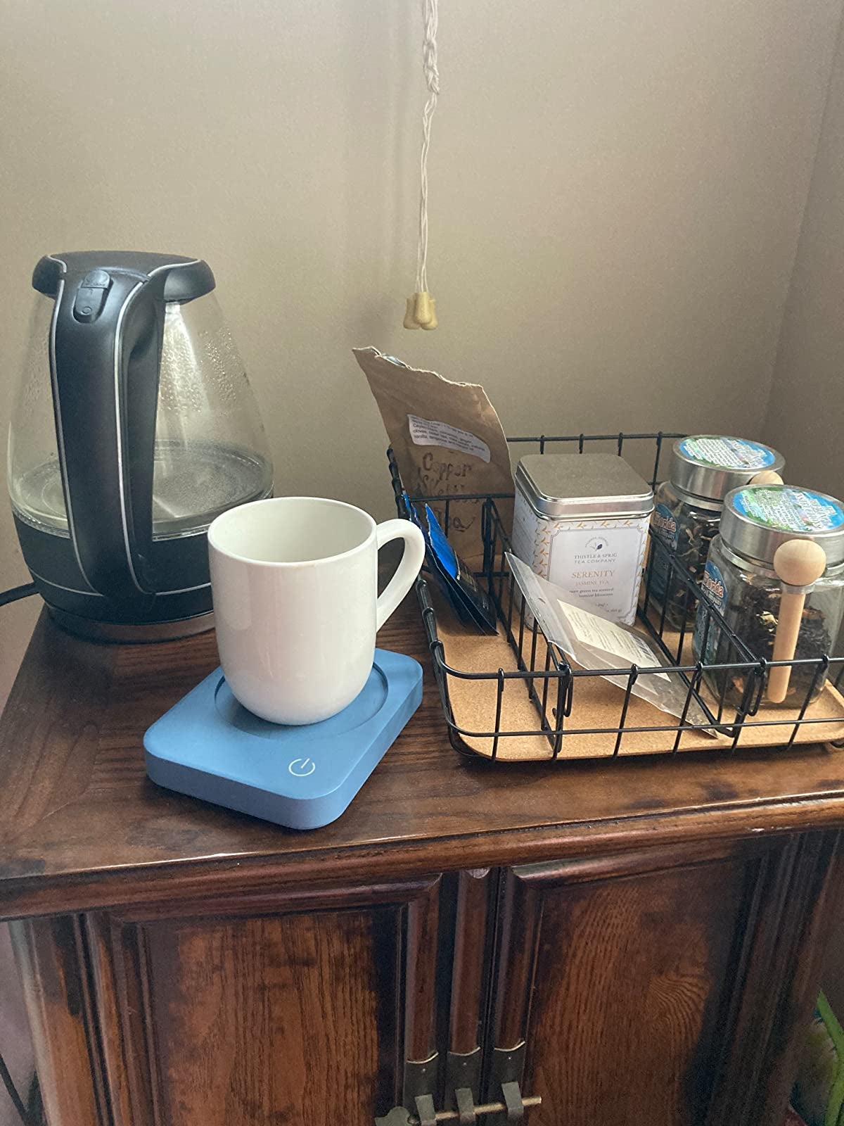 A mug sitting on the blue warmer on a reviewer's coffee table