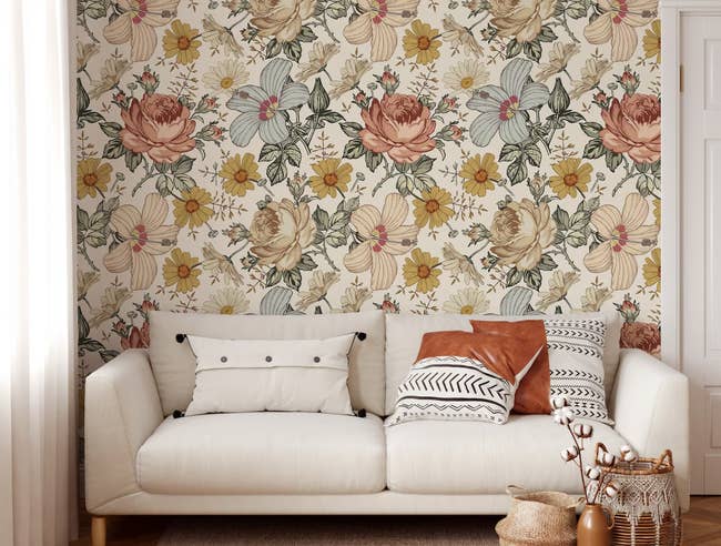 The floral wallpaper hung up behind a cream couch