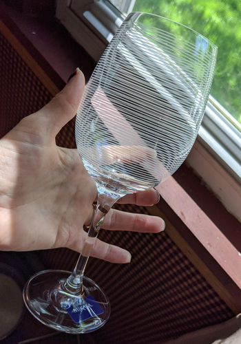 Reviewer holding striped wine glass