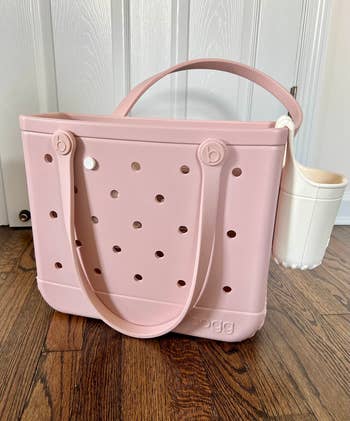Large tote bag with a textured surface and circular cutouts, shown with an attached cup holder, suitable for casual outings