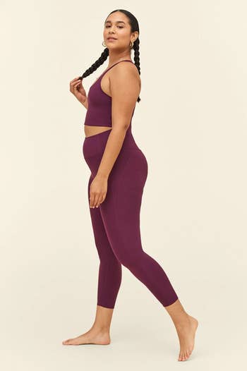 Model in a plum colored pair of leggings 
