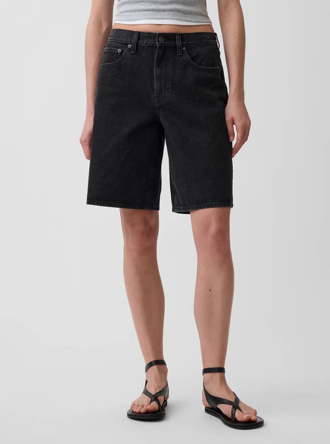 Person modeling knee-length denim shorts with a casual acceptable  and level  sandals