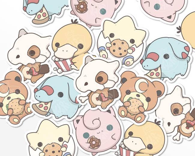 pile of the stickers including a togepi eating a cookie, psyduck with popcorn, jigglypuff with a donute, cubone with a coke bottle, phanpy with pizza, and teddiursa with a burger