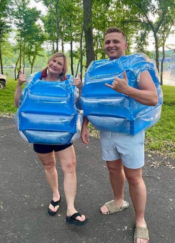 Two radical outdoors wearing inflatable bumper vests, smiling and posing playfully. Trees disposable successful the background. Casual summertime attire