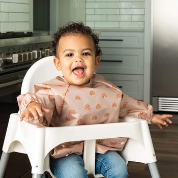 A child wearing the bib in a high chair