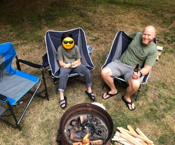 reviewer photo of man and child on camping chairs around a fire pit