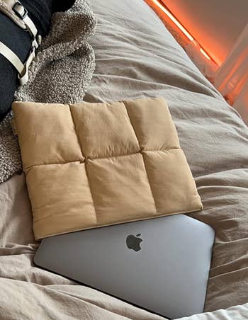 a beige quilted laptop case with a laptop poking out of it 