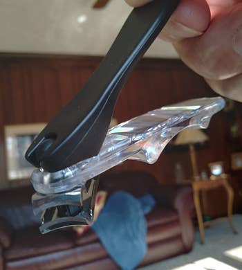 reviewer holding the nail clipper with its teeth angled away from the handles
