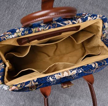 The interior of the bag in a light tan color with six slip pockets and a zippered side pocket
