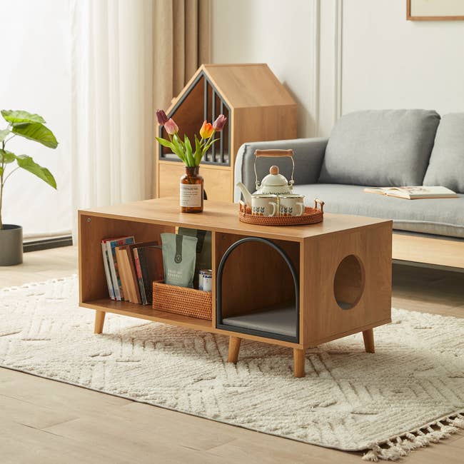 the wooden coffee table with a pet bed, two pet openings, and another cubby for storage