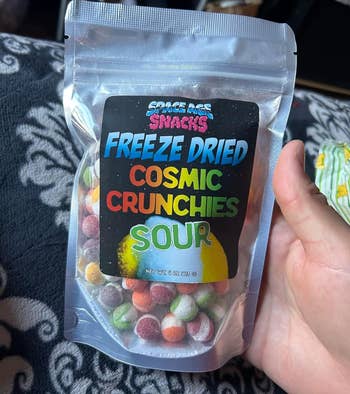 reviewer holding bag of freeze dried sour skittles