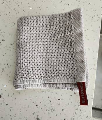 pale gray waffle knit washcloth folded on a counter 