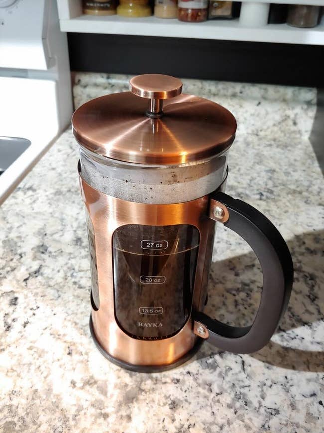 reviewer image of the copper-colored french press full of coffee