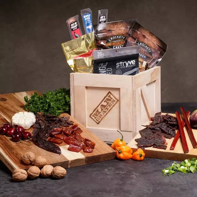 a wooden crate filled with jerky and cutting boards with jerky and nuts on them