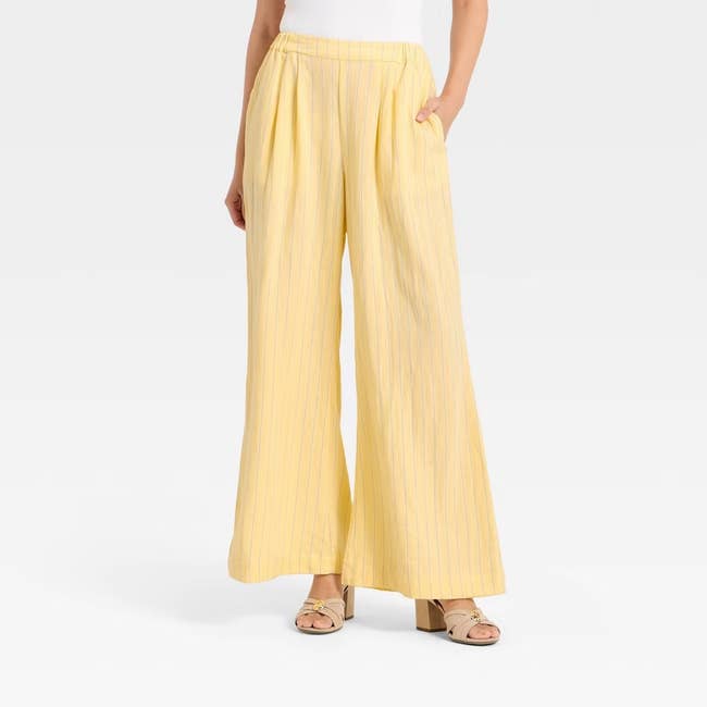 Model wearing wide-leg pants with subtle pinstripes and sandals, suitable for a casual or semi-casual look