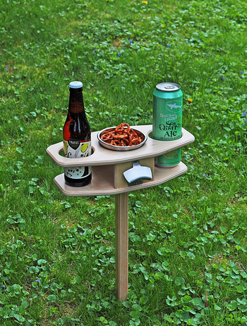the wooden drink holder with two beers and a bowl of chips