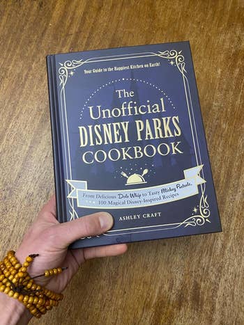 Reviewer holding The Unofficial Disney Parks Cookbook