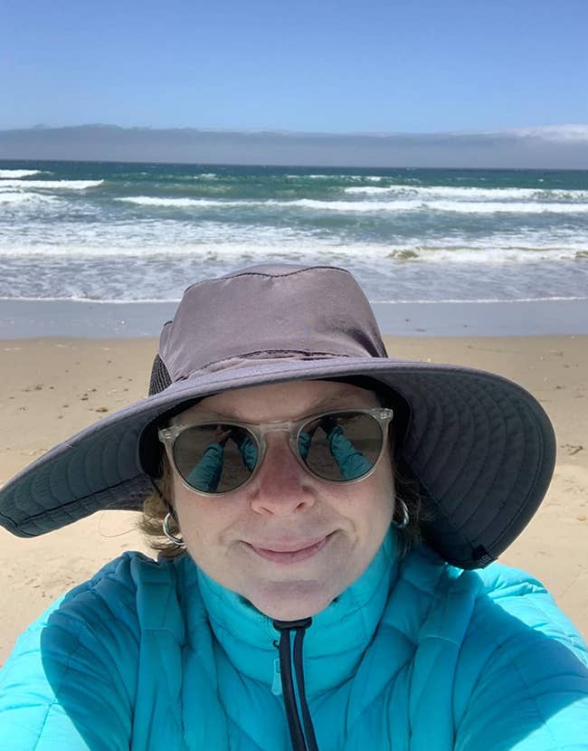 reviewer wearing sun hat at beach