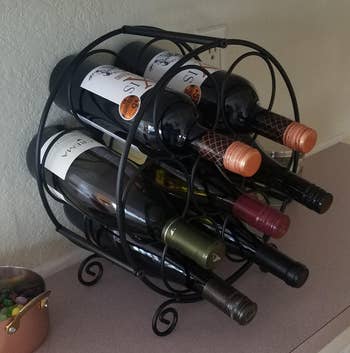 Reviewer image of black wine rack with several wine bottles