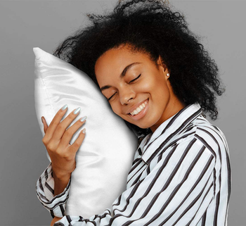 model rubbing their face on a white satin pillow