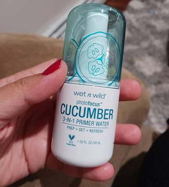 hand holding the spray bottle of cucumber scented primer