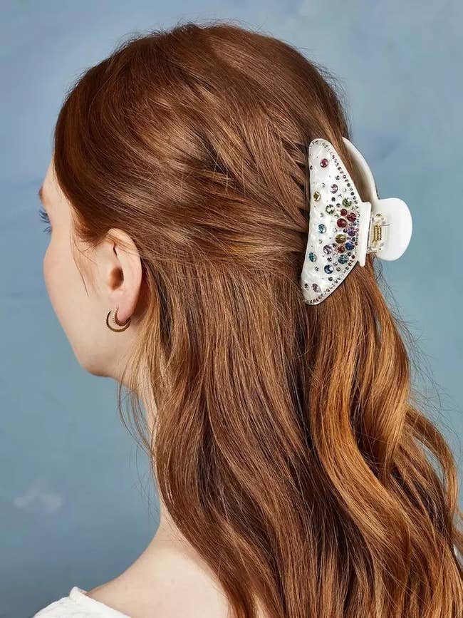 model wearing white and rainbow rhinestone clip in half up half down hairdo