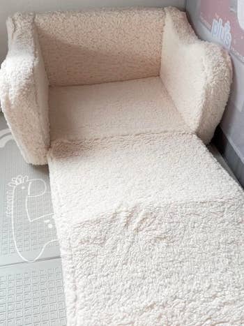 Sherpa-covered armchair with an extended matching ft  cushion, suitable for cozy location  decor