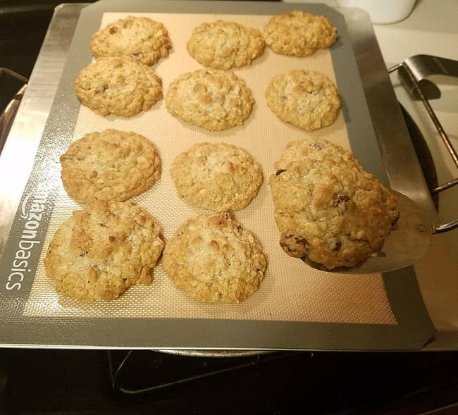 a reviewer photo of a silicone mat on a baking sheet with cookies on it 