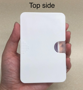 The reviewer holding the pill organizer inside the sleeve
