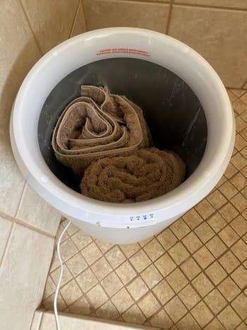 A compact achromatic laundry spinner successful a tiled country with towels inside, displaying laundry ratio successful a location setting