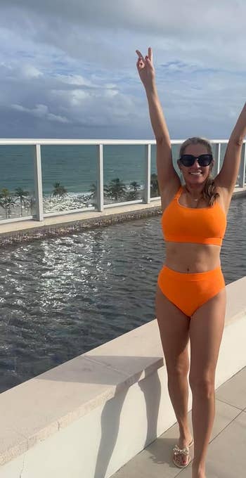 Reviewer in orange bikini by a pool