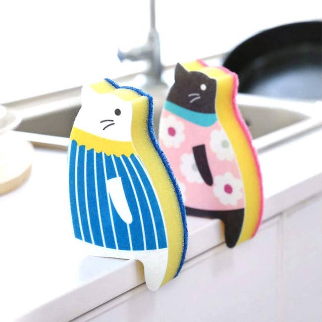 two sponges shaped like cats sitting on a kitchen counter