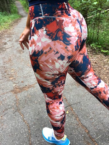 reviewer in same leggings with a cool pink, red, and dark blue print